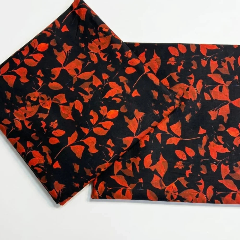 Black fabric with vibrant red leaf print, ideal for autumn-themed fashion or home decor