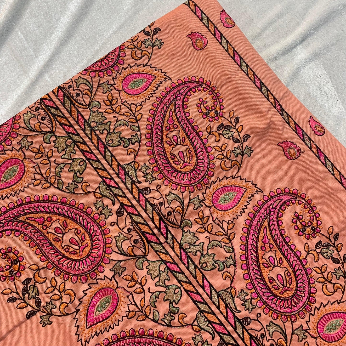 Peach lawn fabric with intricate pink and gold paisley embroidery, ideal for designer ladies suits