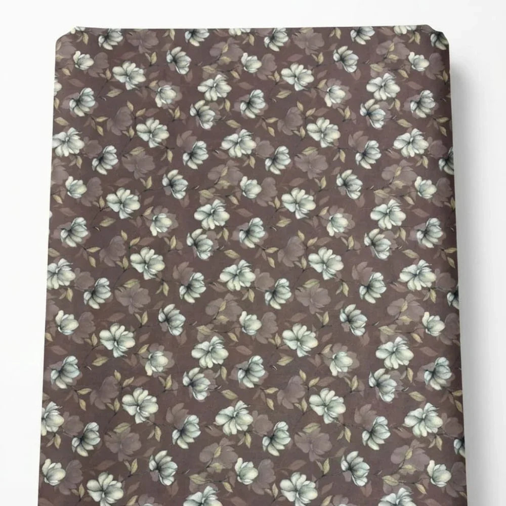 Brown floral fabric with white and green blossoms, ideal for sewing and crafting projects.
