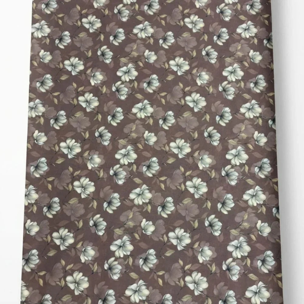 Brown floral fabric with white and green blossoms, ideal for sewing and crafting projects
